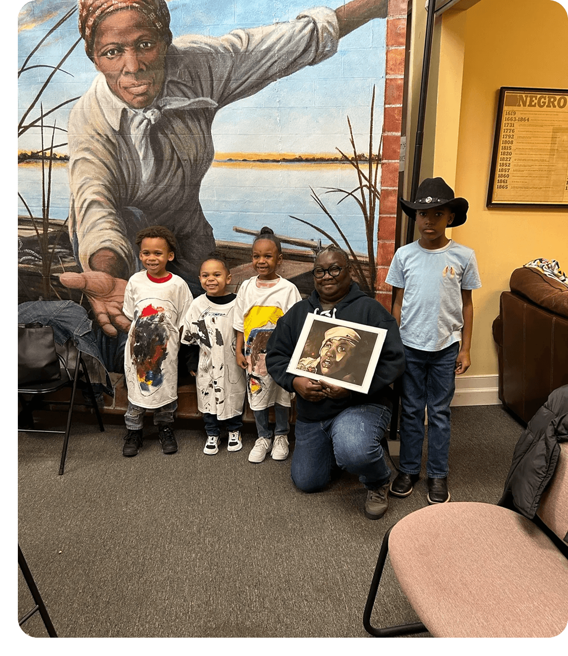 Smiling children and adult with painting
