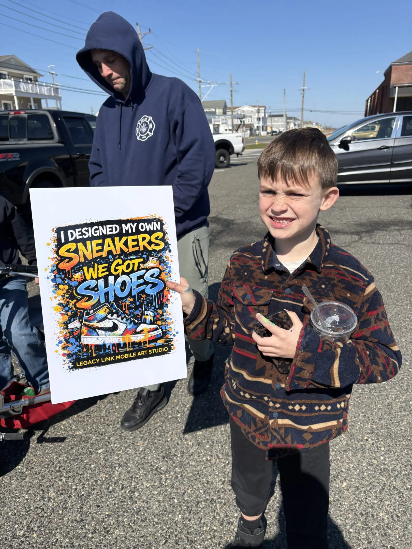 Young boy holding a sign about sneakers versus shoes.