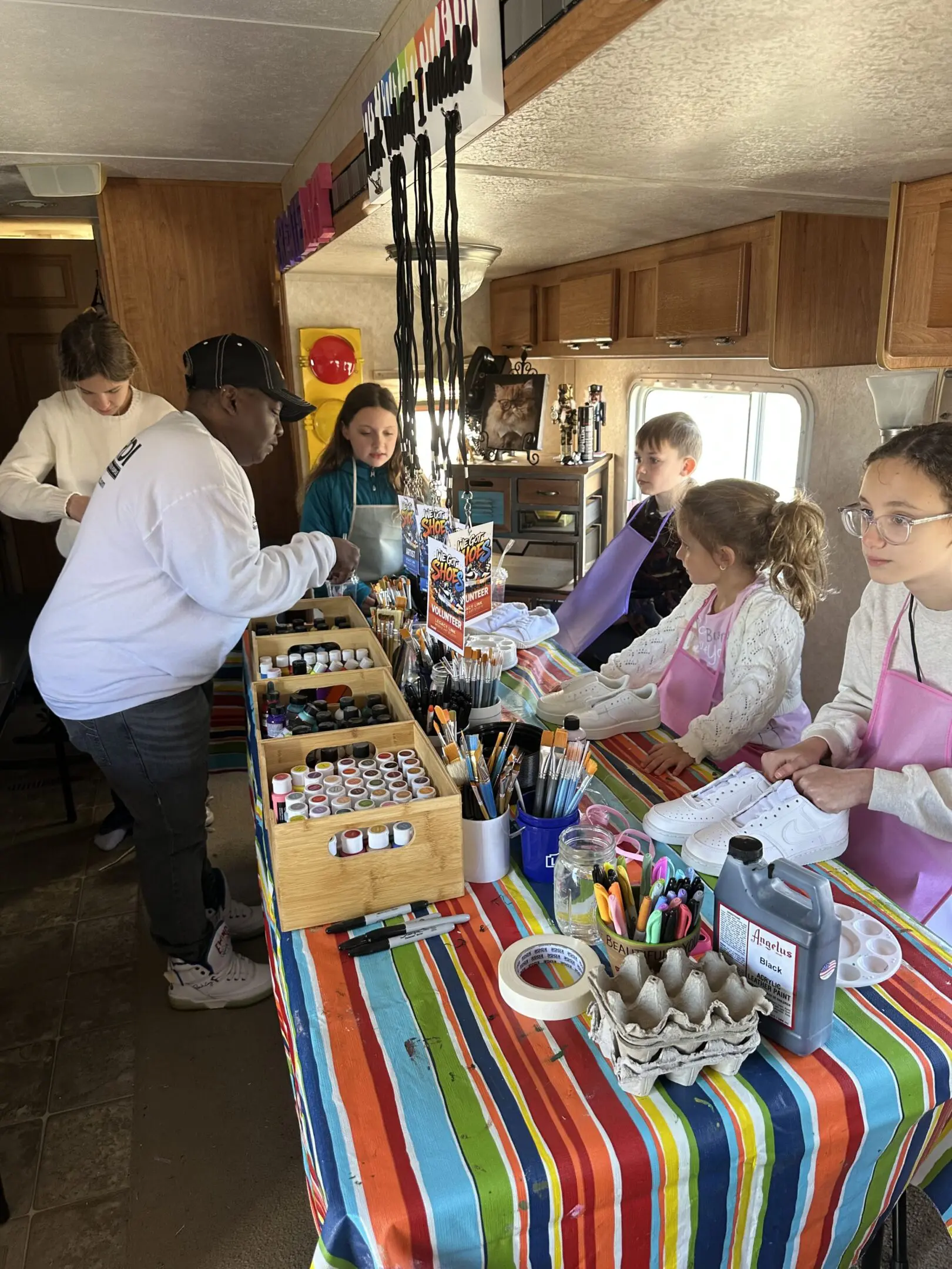 People shopping at a vibrant indoor market stall with handmade goods.